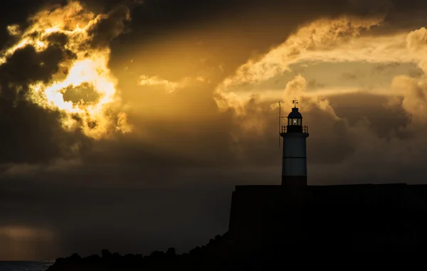 Прекрасне яскраве небо сонця над спокійним океаном з маяком — стокове фото
