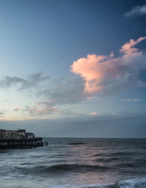 Stunning colorful Winter sunset sky above burned out pier at sea — Stock Photo, Image