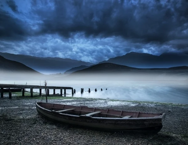 Lama perahu di danau pantai dengan berkabut danau dan pegunungan landscap — Stok Foto