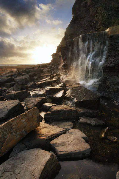 Schöne Landschaft Bild Wasserfall fließt in Felsen am Strand — Stockfoto