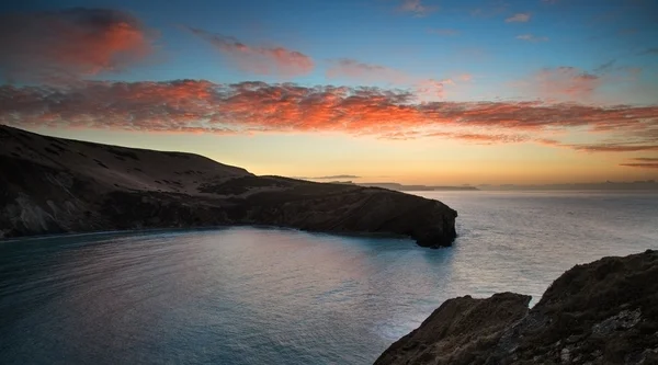 Belo nascer do sol vibrante sobre a costa rochosa — Fotografia de Stock