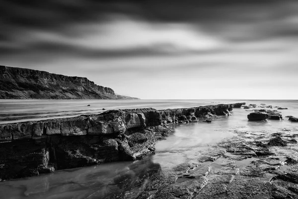 Bellissimo paesaggio bianco e nero di riva rocciosa al tramonto — Foto Stock