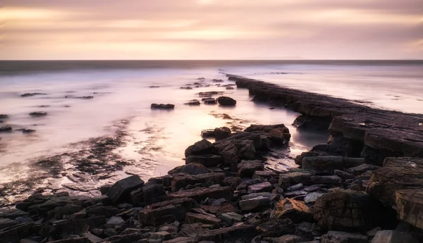 Schöne getönte Meereslandschaft mit felsigem Ufer bei Sonnenuntergang — Stockfoto