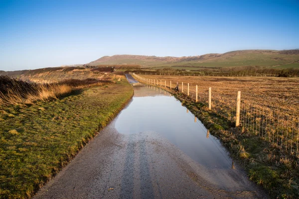 Paisaje imagen de país inundado carril en la granja — Foto de Stock