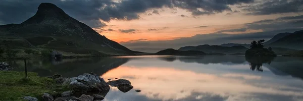 Panoramalandschaft atemberaubender Sonnenaufgang über See in den Bergen — Stockfoto