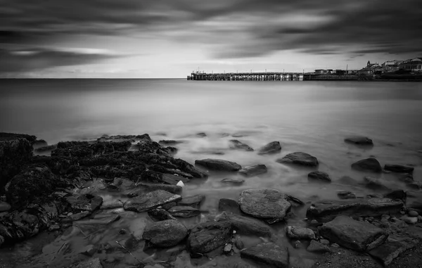 Lunga esposizione paesaggio marino in bianco e nero durante drammatico — Foto Stock