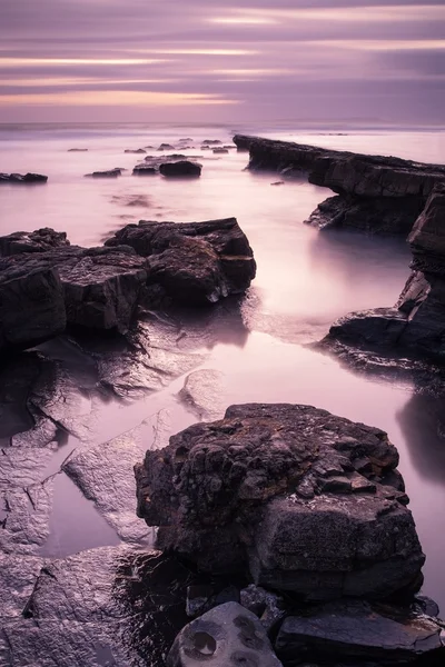 Schöne getönte Meereslandschaft mit felsigem Ufer bei Sonnenuntergang — Stockfoto