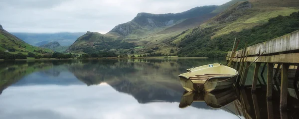 Panorama landscape rowing boats on lake with jetty against mount — Stock Photo, Image