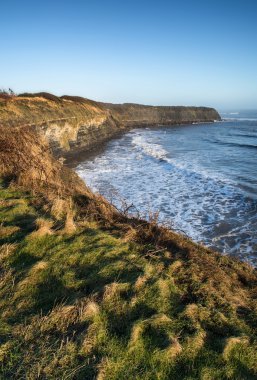 sunrise olan kayalıklarla ve puslu glo adlı güzel sahil peyzaj