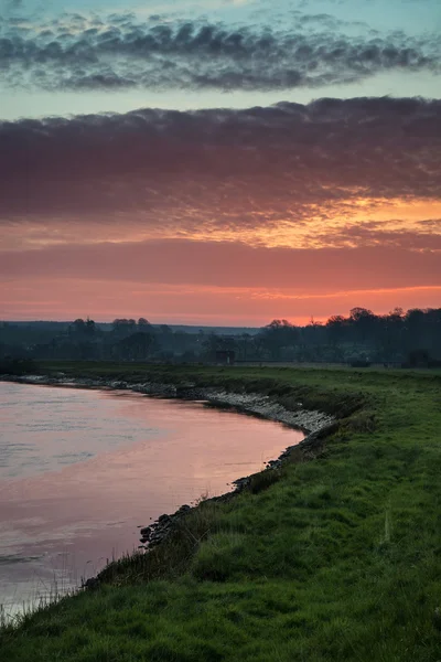 Impresionante amanecer vibrante reflejado en el río tranquilo —  Fotos de Stock