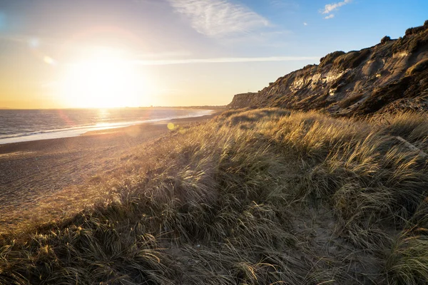 Żywy krajobraz zachód słońca na plaży i klify dodatkowy obiektyw fla — Zdjęcie stockowe