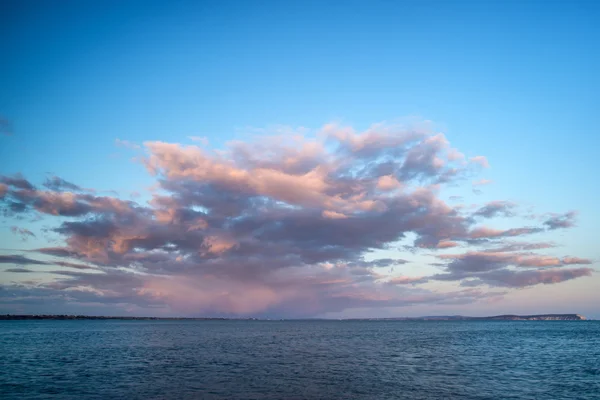 Красивое формирование облаков заката над спокойным морским пейзажем — стоковое фото
