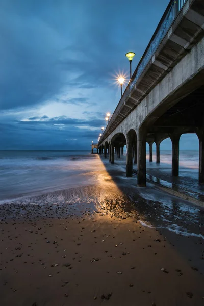 Twilight dusk landscape of pier stretching out into sea with moo — Stock Photo, Image