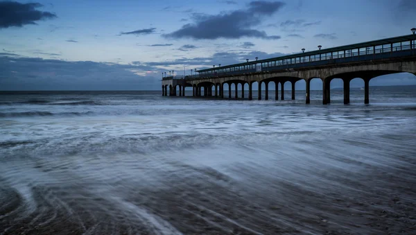 Morgendämmerungslandschaft mit Seebrücke, die sich ins Meer erstreckt — Stockfoto