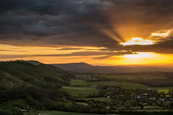 Stunning vibrant Summer sunset over escarpemt landscape — Stock Photo, Image