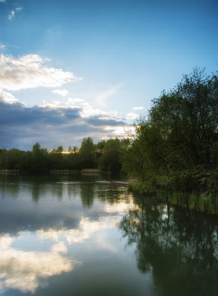 Summer vibrant sunset reflected in calm lake waters — Stock Photo, Image