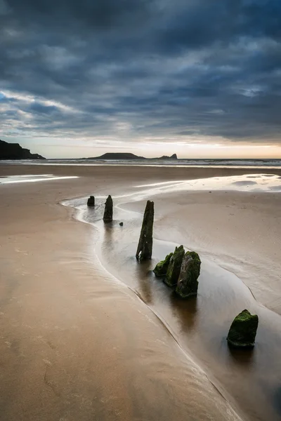 Landscape with old groynes protruding from sand on Rhosilli Bay — Stock Photo, Image