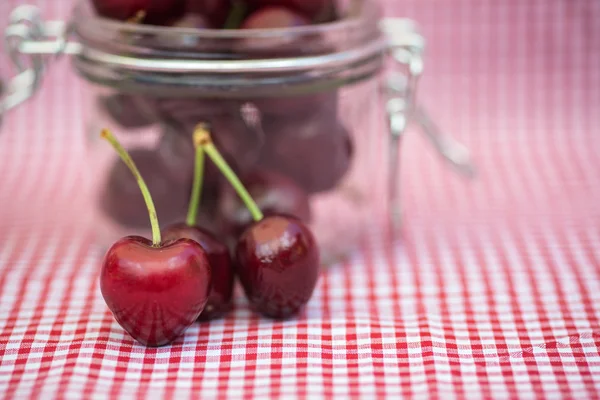 Tarro de vidrio lleno de cerezas frescas — Foto de Stock