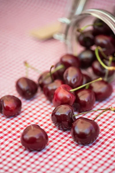 Tarro de vidrio lleno de cerezas frescas — Foto de Stock