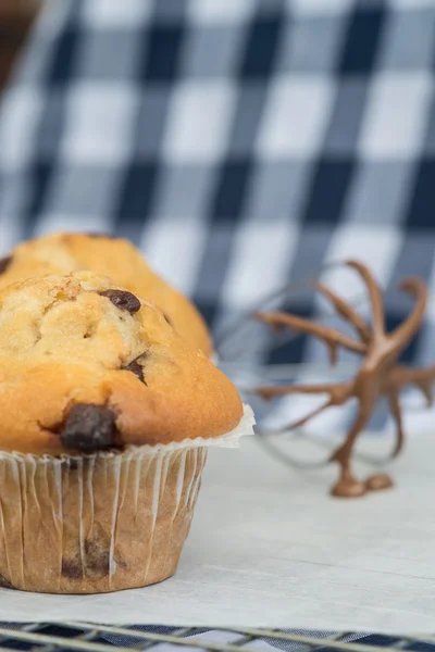 Tasty home made muffins with whisk covered in melting chocolate — Stock Photo, Image