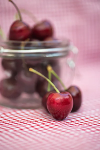 Tarro de vidrio lleno de cerezas frescas — Foto de Stock