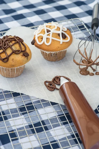 Florsocker glasyr sätts på hem gjorde chocolate chip muffins — Stockfoto