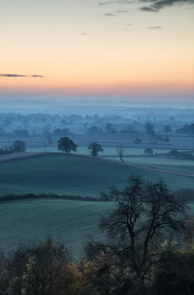 Impressionante nascer do sol sobre camadas de nevoeiro na paisagem rural — Fotografia de Stock