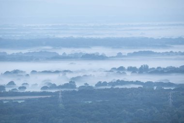 Sersemletici sisli bir sabah manzarası. Yaz sonu İngiliz kırsalındaki South Downs Ulusal Parkı 'ndaki tarlalara bakıyor.