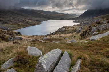Sonbaharın erken saatlerinde Ogwen Vadisi boyunca Llyn Ogwen ve Tryfan 'ın karamsar gökyüzü altında fotokopi alanı ile manzara.