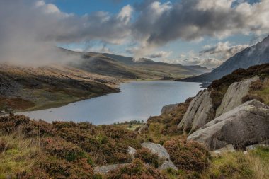 Sonbaharın erken saatlerinde Ogwen Vadisi boyunca Llyn Ogwen ve Tryfan 'ın karamsar gökyüzü altında fotokopi alanı ile manzara.