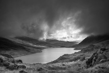 Ogwen Vadisi boyunca Llyn Ogwen ve Tryfan ile birlikte karanlık akşam gökyüzü altında fotokopi uzayıyla birlikte siyah ve beyaz sonbahar dönemi manzarası