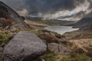 Sonbaharın erken saatlerinde Ogwen Vadisi boyunca Llyn Ogwen ve Tryfan 'ın karamsar gökyüzü altında fotokopi alanı ile manzara.