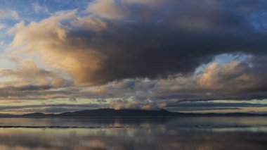 Solway Firth 'ün çarpıcı sonbahar günbatımında dramatik gökyüzü ve bulut oluşumlarıyla Silloth' tan çekilmiş destansı günbatımı manzarası.