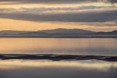Solway Firth 'ün çarpıcı sonbahar günbatımında dramatik gökyüzü ve bulut oluşumlarıyla Silloth' tan çekilmiş destansı günbatımı manzarası.