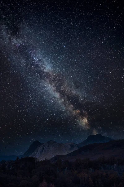 Digital composite image of Milky Way and Epic landscape image of stunning Langdale Pikes looking from Holme Fell in Lake District