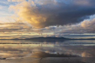 Solway Firth 'ün çarpıcı sonbahar günbatımında dramatik gökyüzü ve bulut oluşumlarıyla Silloth' tan çekilmiş destansı günbatımı manzarası.