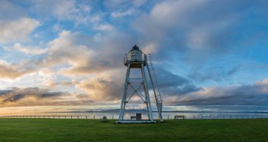 Dumfries ve Galloway dağlarının olduğu Silloth deniz fenerinin güzel sonbahar günbatımı manzarası
