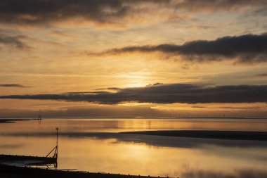 Solway Firth 'ün çarpıcı sonbahar günbatımında dramatik gökyüzü ve bulut oluşumlarıyla Silloth' tan çekilmiş destansı günbatımı manzarası.