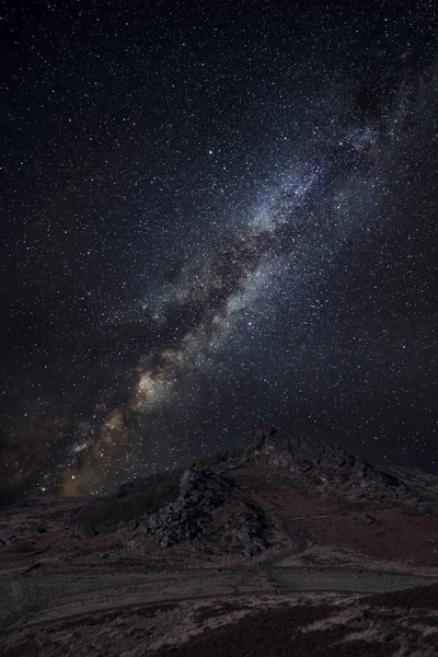 数字复合银河夜空的拉锯岩陡峭的山顶区冬季景观 — 图库照片