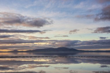 Solway Firth 'ün çarpıcı sonbahar günbatımında dramatik gökyüzü ve bulut oluşumlarıyla Silloth' tan çekilmiş destansı günbatımı manzarası.