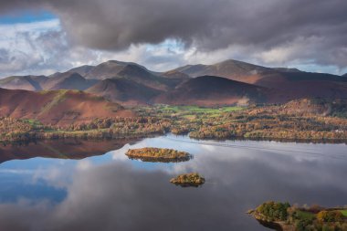 Göl Bölgesi 'ndeki Walla Crag' dan Derwentwater 'ın üzerinden Catbell' lere ve çarpıcı sonbahar renkleriyle uzak dağlara bakan destansı sonbahar manzarası.