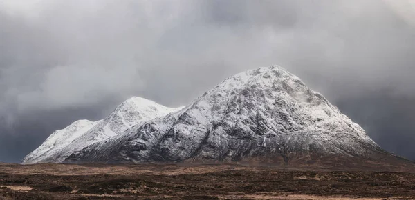 Stob Dearg Buachaille Etive Mor 'un kış manzarası. Rannoch Moor' dan karlı zirvesi ve güzel dramatik bulut oluşumlarıyla izleniyor.