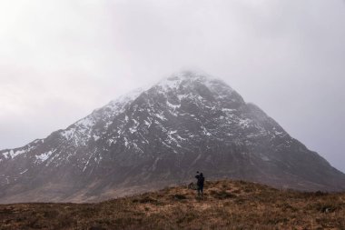 İskoçya 'nın kuzeyindeki Rannoch Bozkırı boyunca uzanan güzel kış manzarası Buachaille' e doğru Etive Mor Stob Dearg ön planda tanımlanamayan bir fotografçıyla