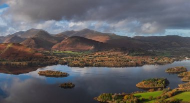 Göl Bölgesi 'ndeki Walla Crag' dan Derwentwater 'ın üzerinden Catbell' lere ve çarpıcı sonbahar renkleriyle uzak dağlara bakan destansı sonbahar manzarası.