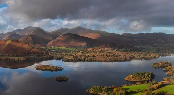 Göl Bölgesi 'ndeki Walla Crag' dan Derwentwater 'ın üzerinden Catbell' lere ve çarpıcı sonbahar renkleriyle uzak dağlara bakan destansı sonbahar manzarası.