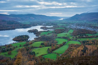 Göl Bölgesi 'ndeki Walla Crag' dan Derwentwater 'ın üzerinden Catbell' lere ve çarpıcı sonbahar renkleriyle uzak dağlara bakan destansı sonbahar manzarası.