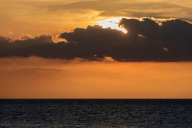 Okyanus manzarası üzerinde çarpıcı, derin, canlı gün batımı. 