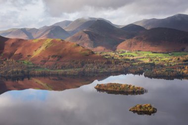 Göl Bölgesi 'ndeki Walla Crag' dan Derwentwater 'ın üzerinden Catbell' lere ve çarpıcı sonbahar renkleriyle uzak dağlara bakan destansı sonbahar manzarası.