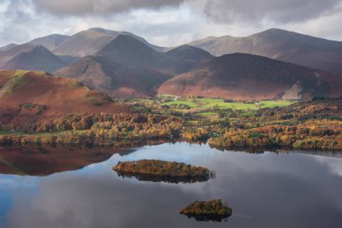 Göl Bölgesi 'ndeki Walla Crag' dan Derwentwater 'ın üzerinden Catbell' lere ve çarpıcı sonbahar renkleriyle uzak dağlara bakan destansı sonbahar manzarası.
