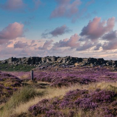 Beautiful landscape image in late Summer of Stanage Edge in Peak District England with stunning clouds formations